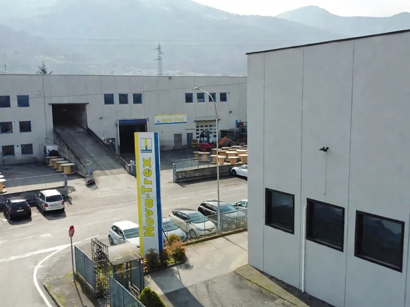 Esterno dello stabilimento Nova-Trex ad Artogne, con insegna e bobine nel piazzale